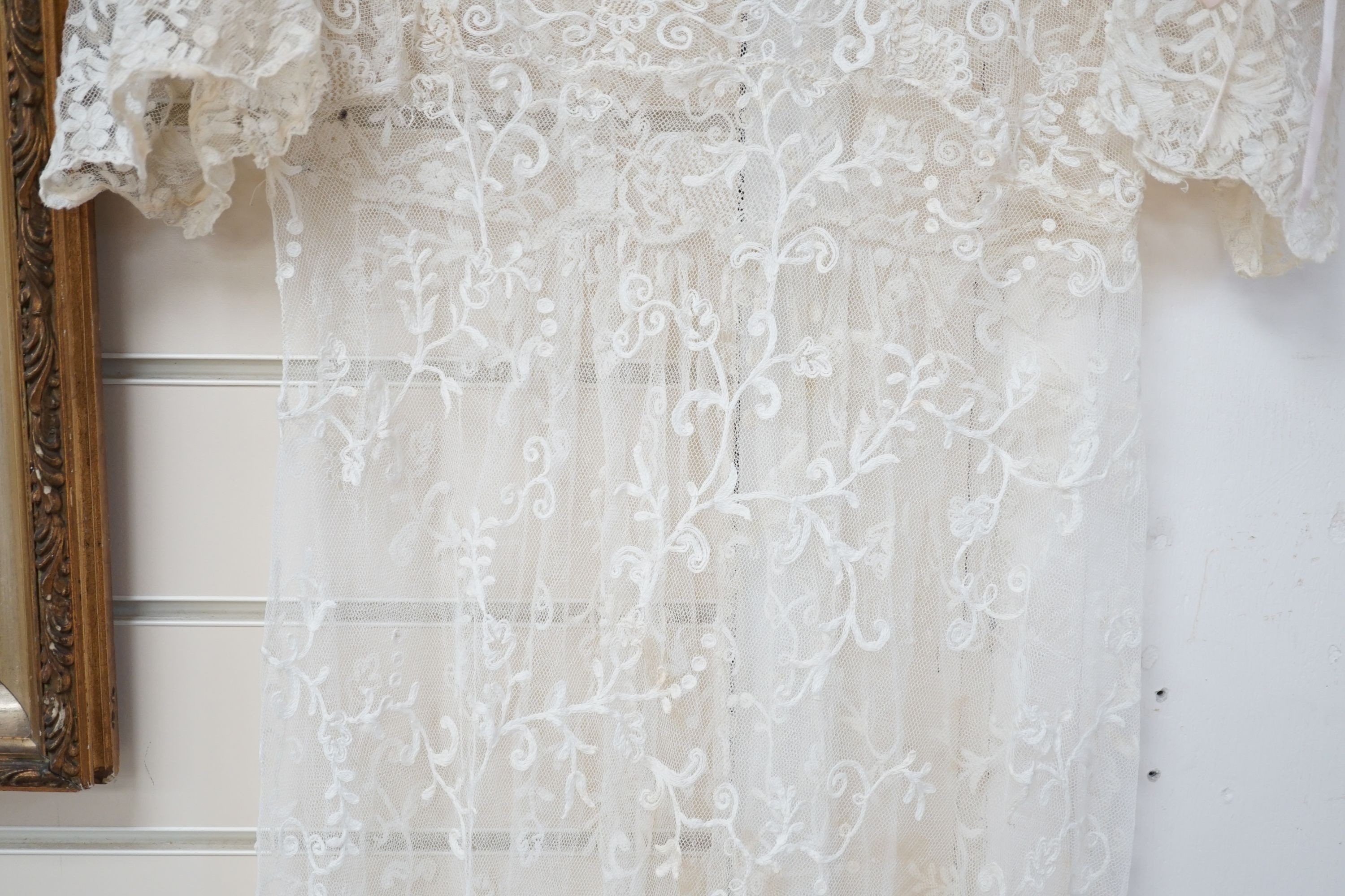 An early 20th century needle run on net lace wedding dress, 155 cms long.